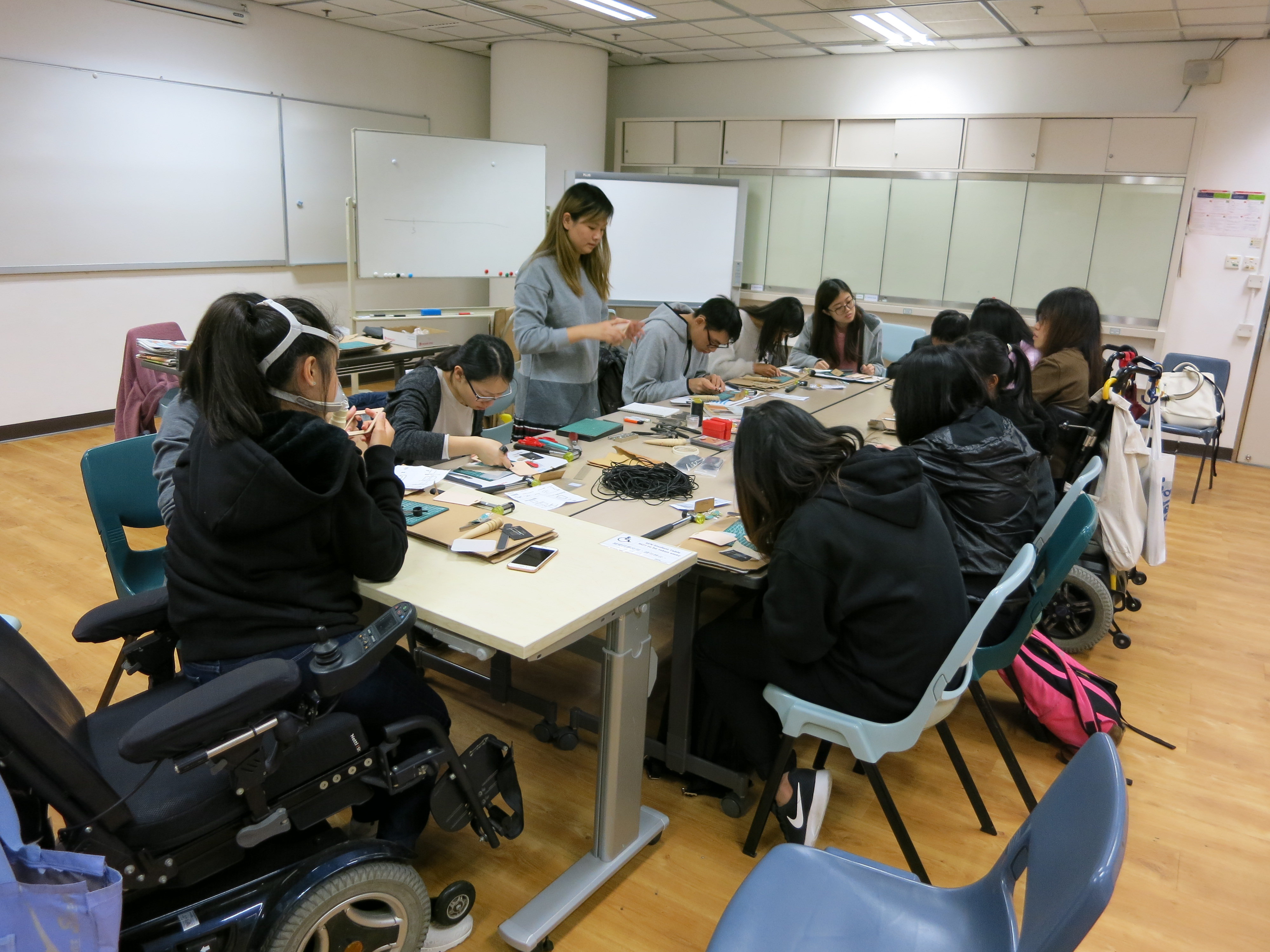 Students were making a leather card holder step-by-step taught by the teacher. 